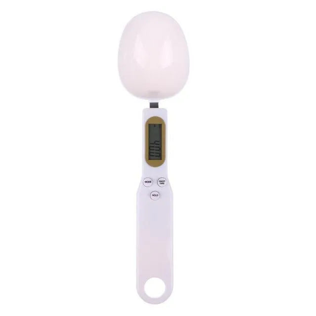 White digital spoon scale with LCD display measuring 500g capacity on a kitchen surface