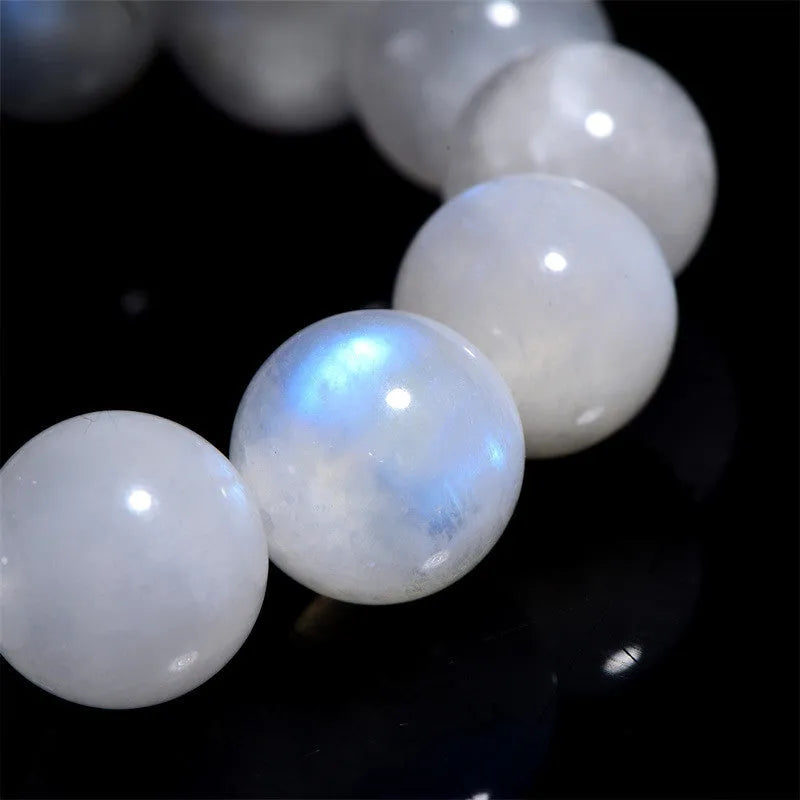 Natural blue moonlight polished round moonstone bead bracelet on a white background.