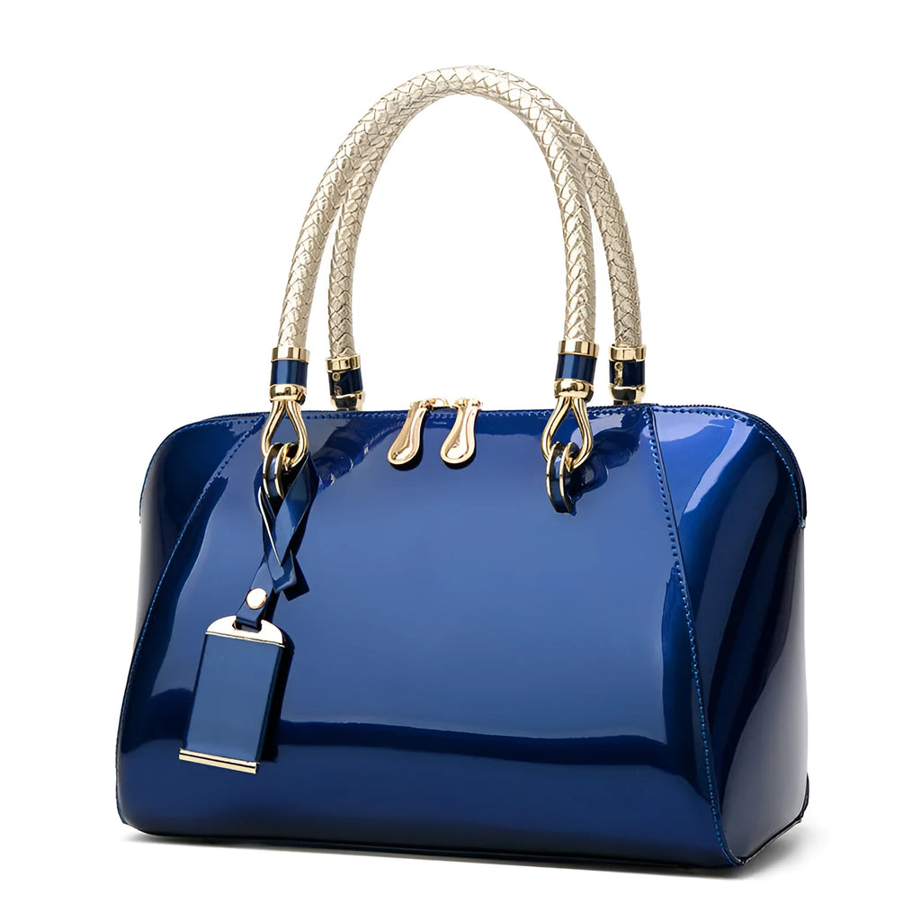 Shiny blue PVC patent leather handbag with lock closure and crossbody strap on a white background
