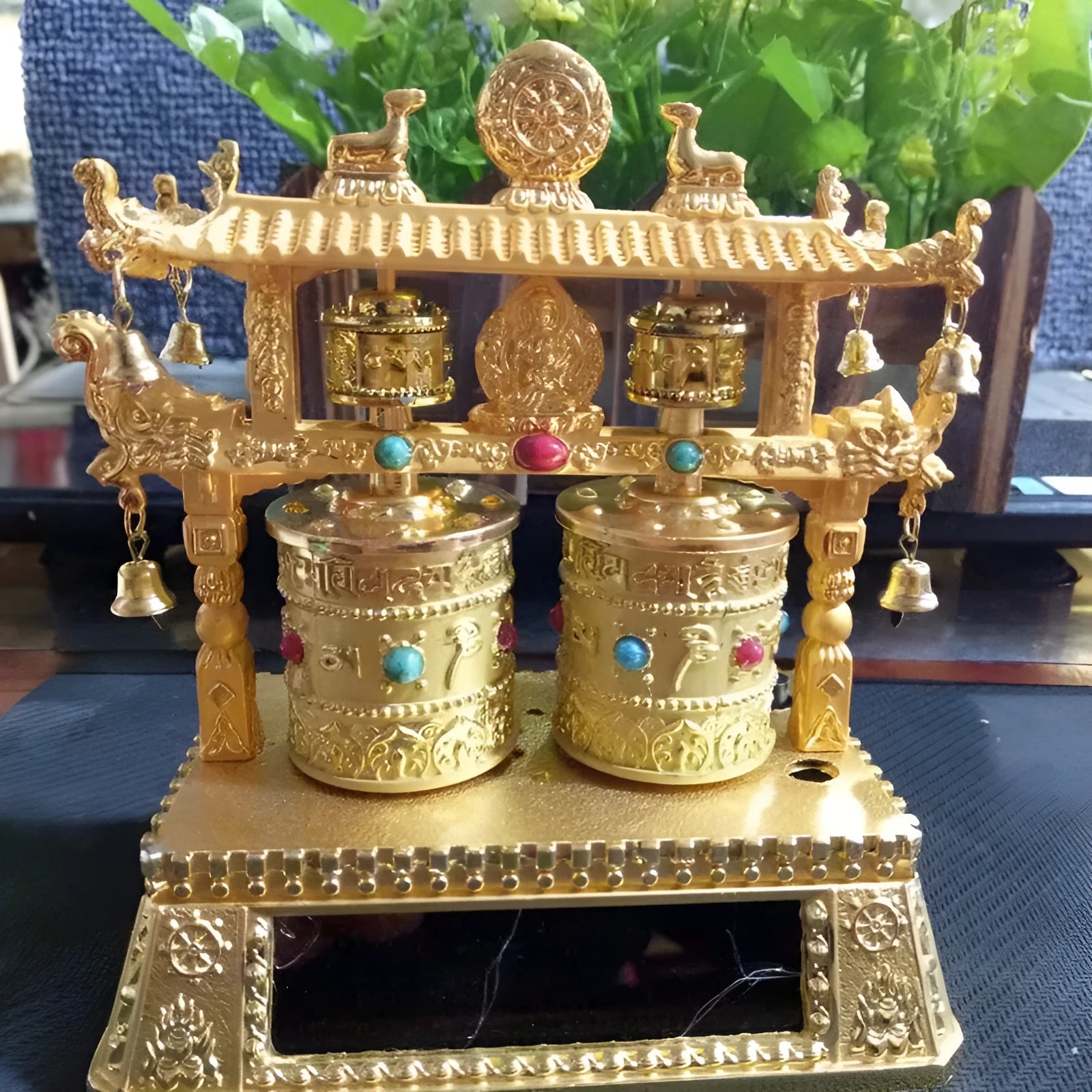 Alloy rotating prayer wheel car decoration in traditional Chinese style on a car dashboard.