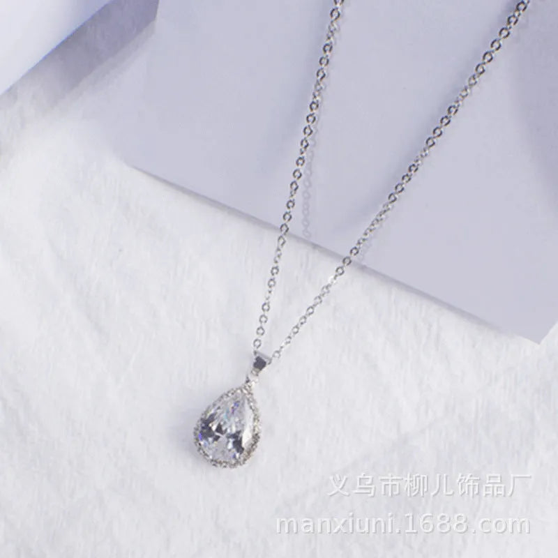Close-up of a women's pink rose gold drop necklace with geometric rhinestone patterns on an alloy setting.