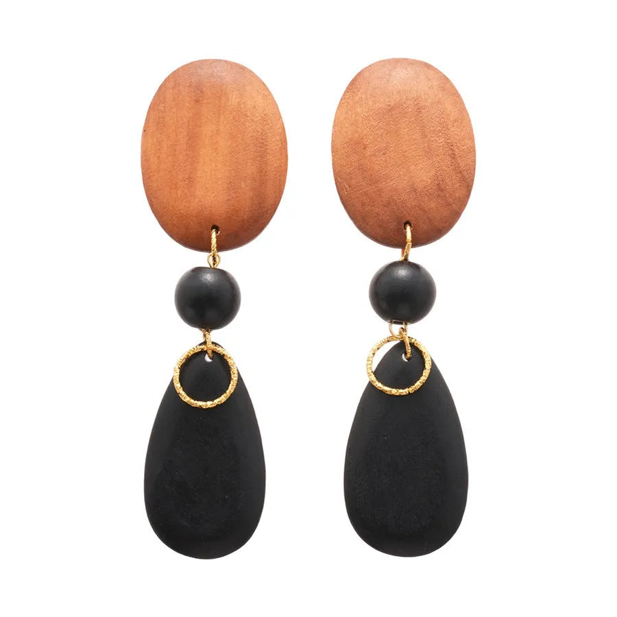 A pair of brown and black wooden ellipse earrings with a retro design on a plain background.