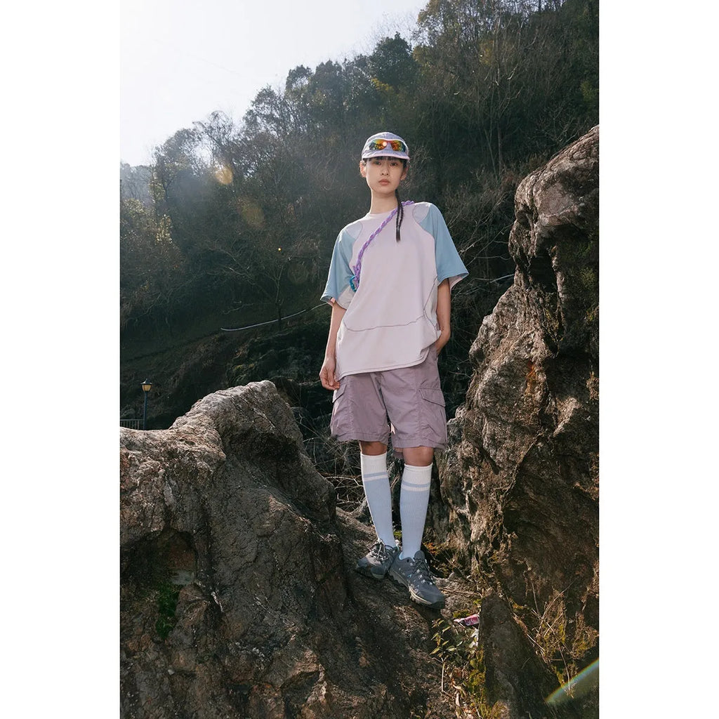 Men's loose blue patchwork t-shirt with raglan short sleeves on a white background.