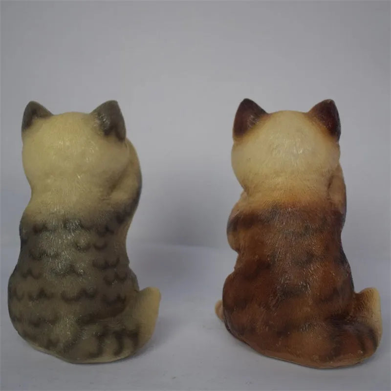 Brown resin solar-powered cat lawn light with LED illumination in a garden setting.