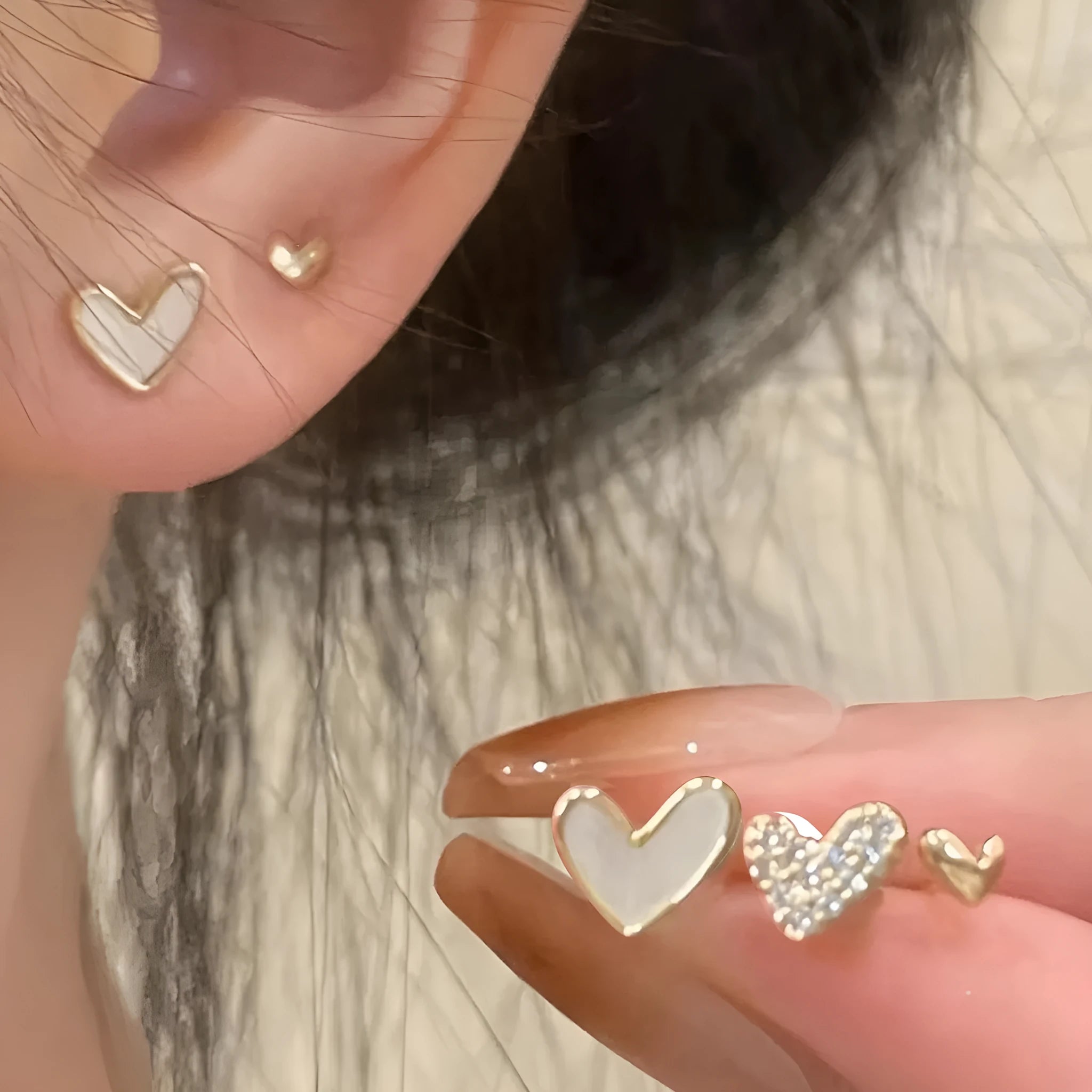 Three pairs of heart-shaped women's earrings in gold, black, and pink colour options