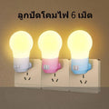 Compact white plug-in bedside baby night light on a table.