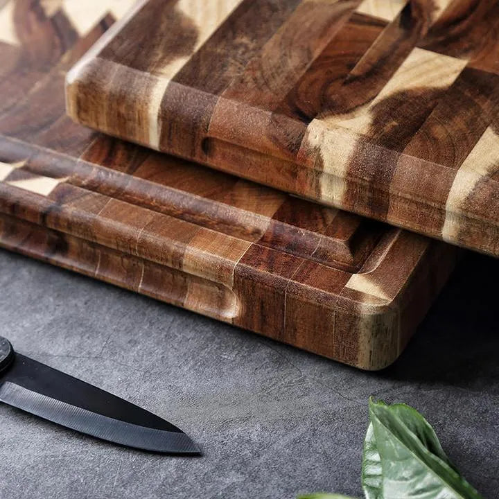 Brown solid wood chopping board with parquet pattern, shown on a kitchen countertop.