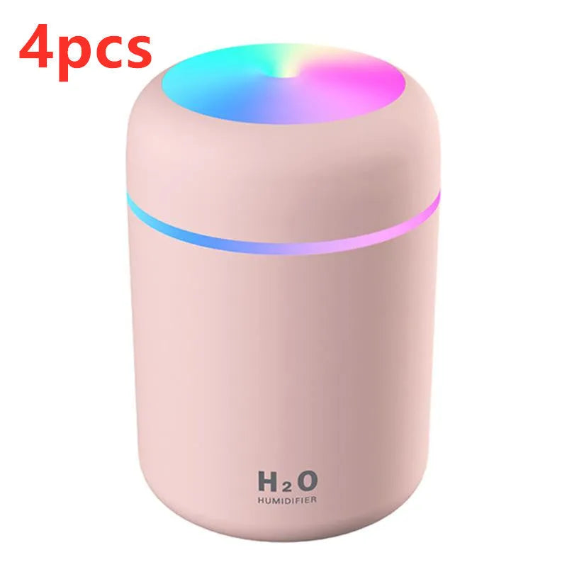 Pink USB desktop humidifier with colourful lights and 300ml water tank on wooden surface