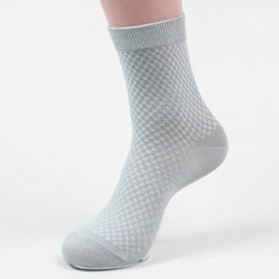 Men's bamboo fibre ankle socks in black with a small square pattern, laid flat.