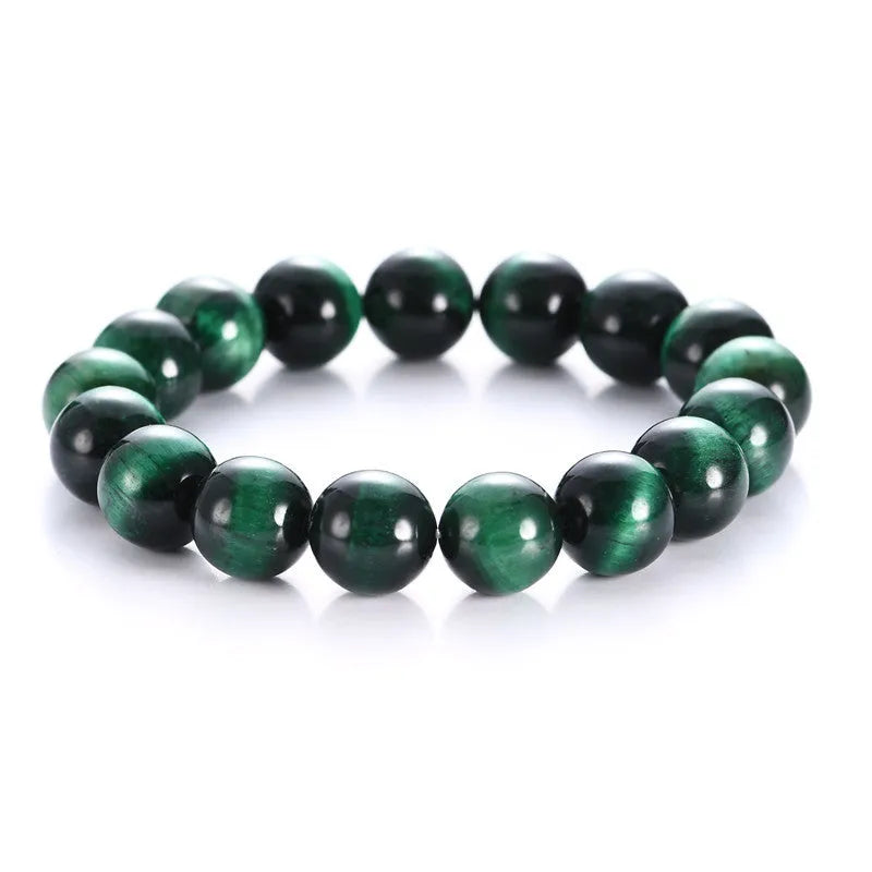 A natural green tiger eye stone bracelet with polished geometric beads on a wrist.