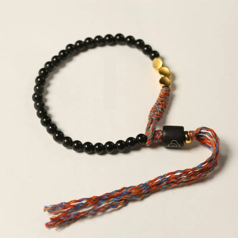 Slender dark obsidian hand-woven bracelet strap shown on a wrist