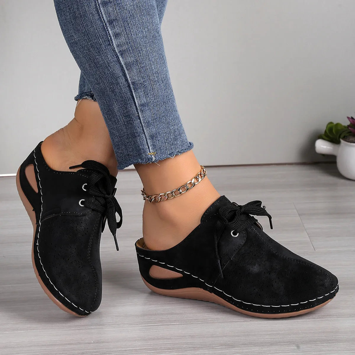 Women's black lace-up wedge slippers with a suede upper and rubber sole on a white background.