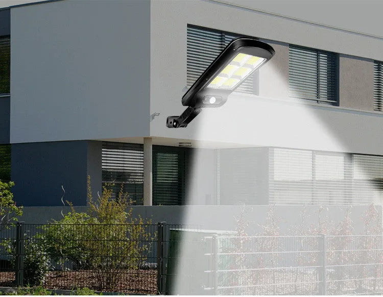Black solar-powered outdoor motion sensor light mounted on a wall.