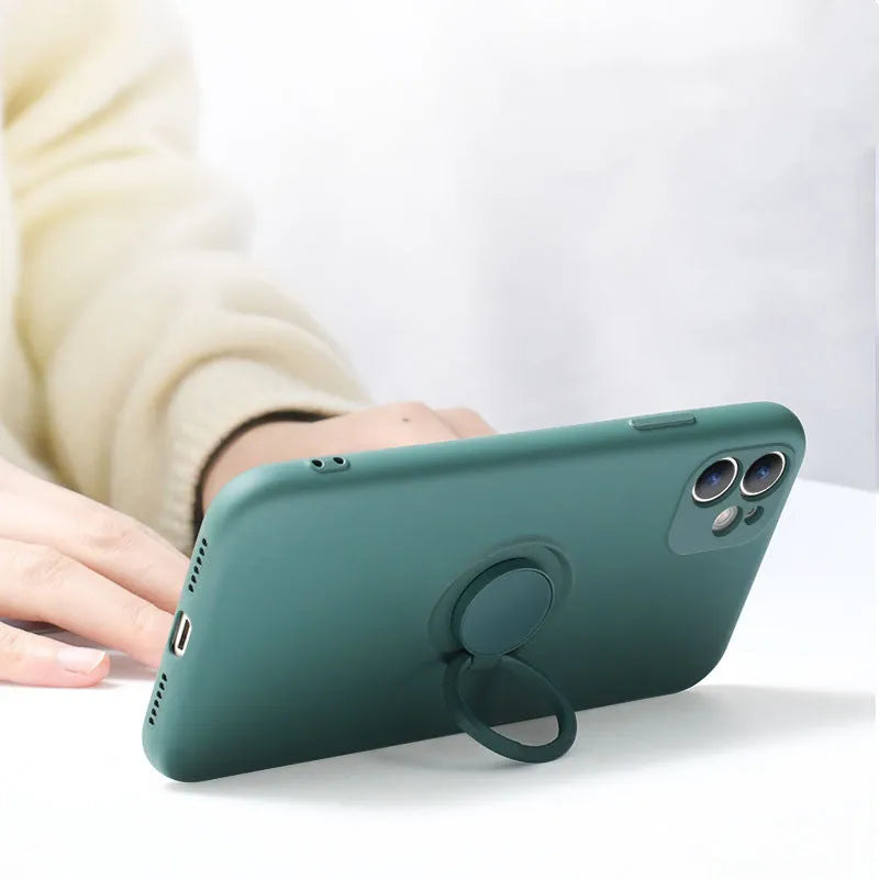 Black silicone iPhone case with a built-in metallic ring bracket on the back, shown fitted to an iPhone 12.