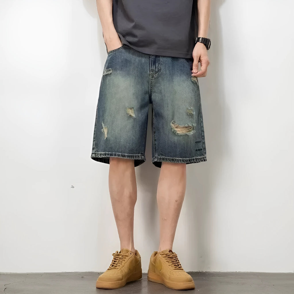 Blue distressed denim men's shorts with a loose retro fit and hole detailing