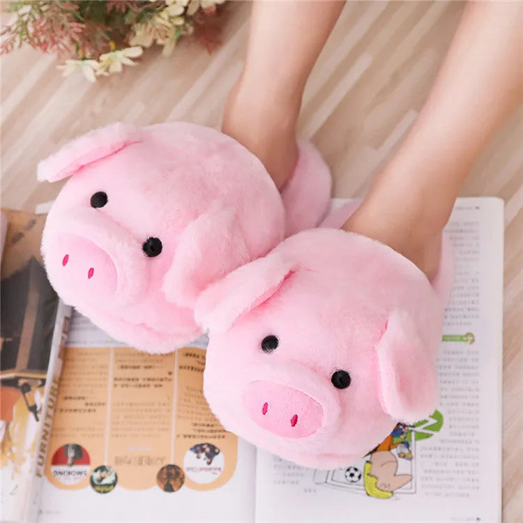 Pink pig-themed plush floor slippers for adults on a plain background.