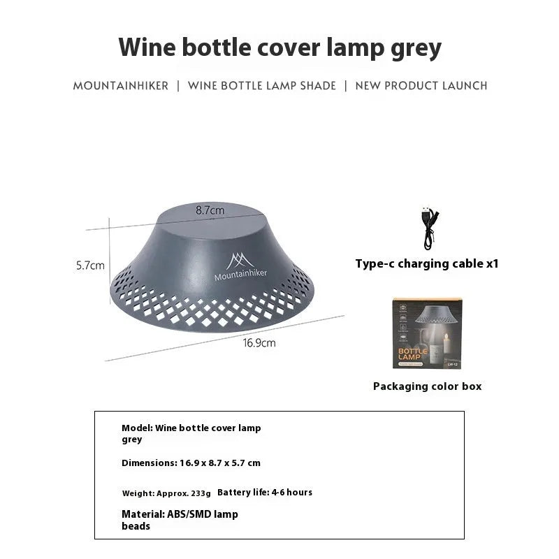 Beige and grey wine bottle shaped camping lantern with USB-C port on a wooden table.