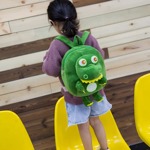 Blue dinosaur plush backpack with embroidered character, soft handle, and backpack straps showing 20-litre capacity