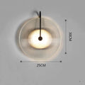 Round glass wall lamp in gold finish mounted on a wall with iron body and clear glass lampshade