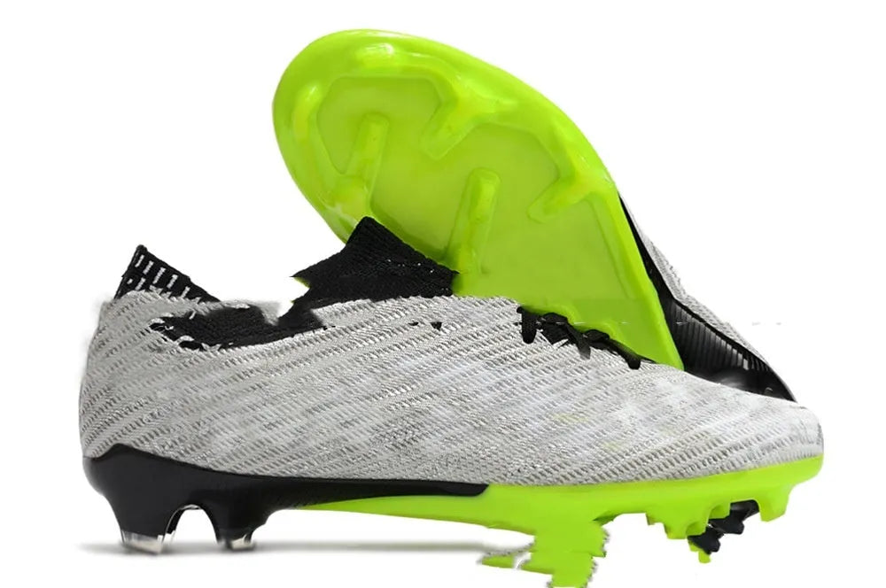Men's black football shoes with knitted upper, FG studs, and lace-up closure shown on grass surface