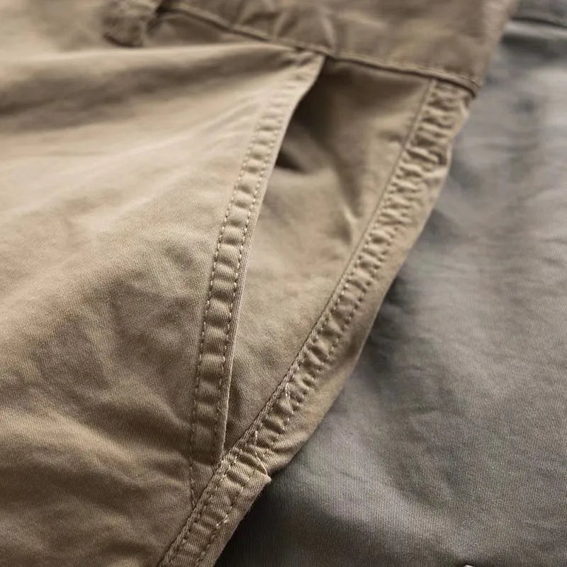 Men's solid colour cotton trousers with multiple pockets in a cropped length, shown in khaki, grey, black, and blue.