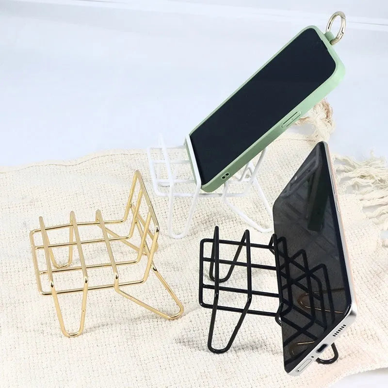 Wrought iron desktop mobile phone bracket in black chair support design on a wooden desk