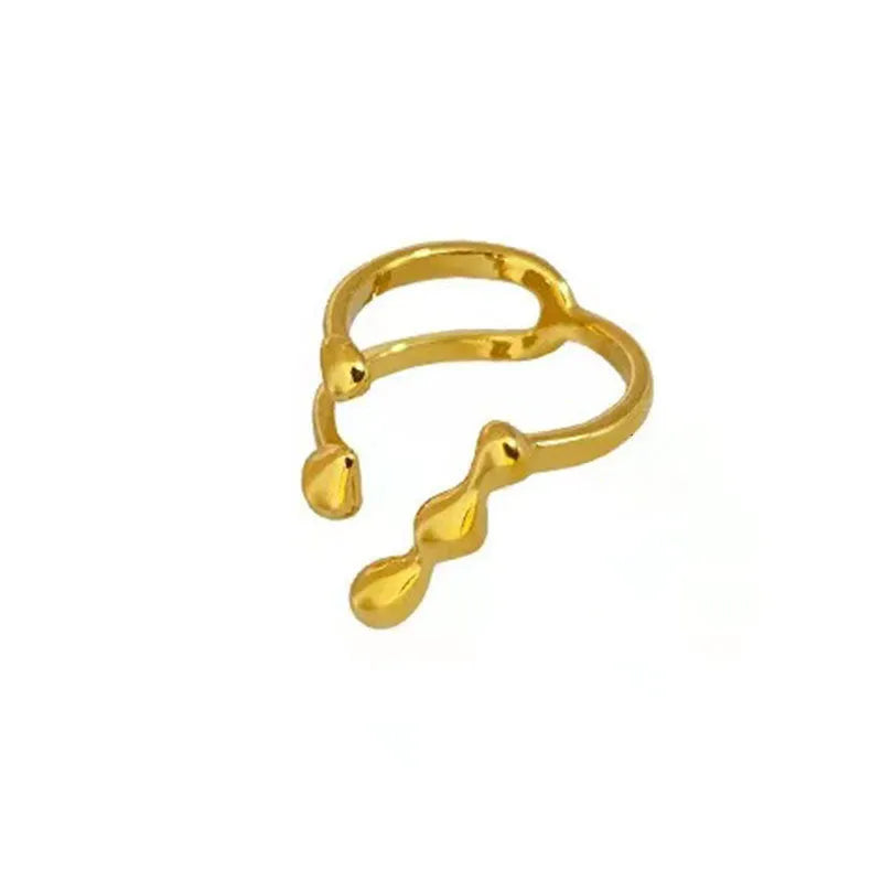 Gold tone brass opening ring with spherical circular design on a finger.