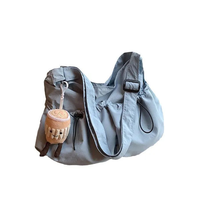 Green pleated polyester crossbody bag showing split pocket design and foldable construction
