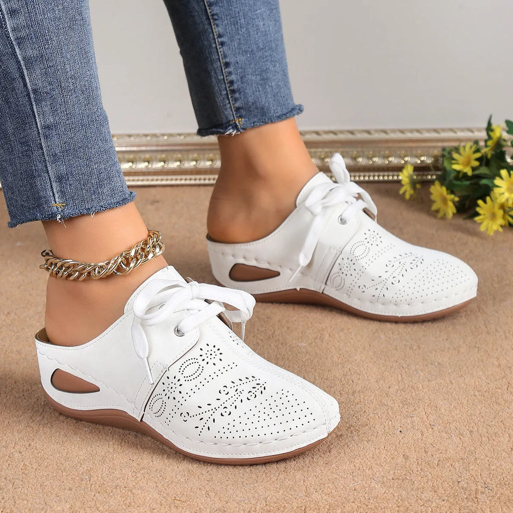 Women's black lace-up wedge slippers with a suede upper and rubber sole on a white background.