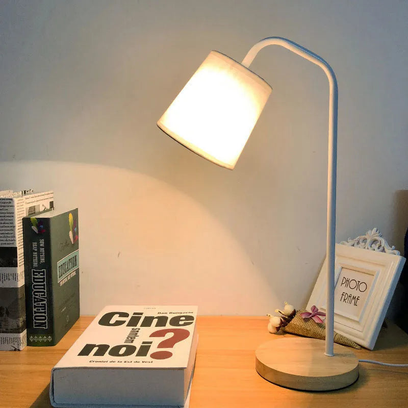 A modern LED table lamp with a push button dimmer switch on its base.