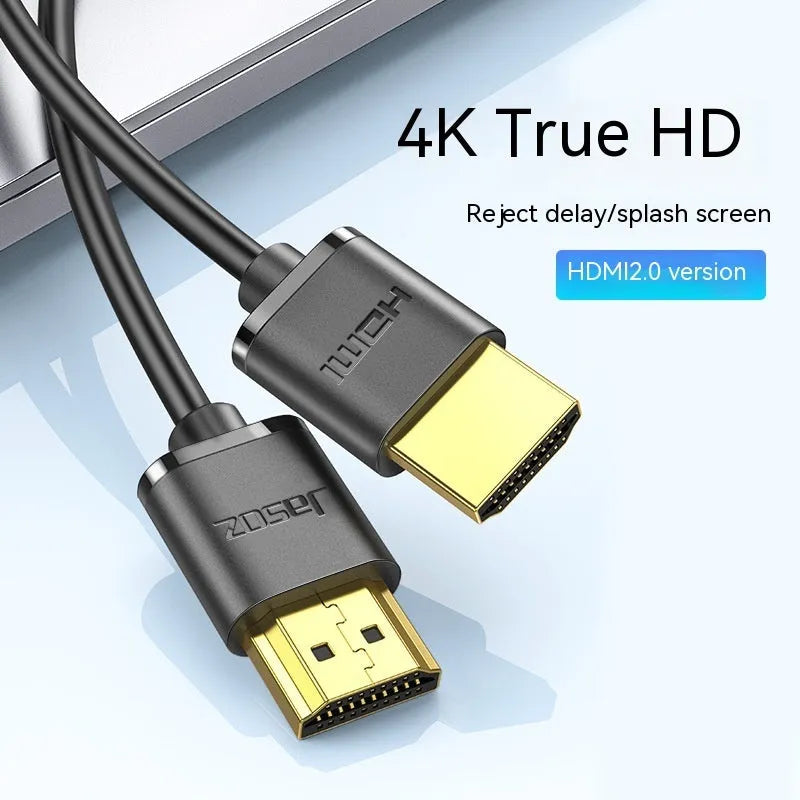 Close-up of a black HDMI cable with gold-plated connectors and a flexible cord on a grey background.