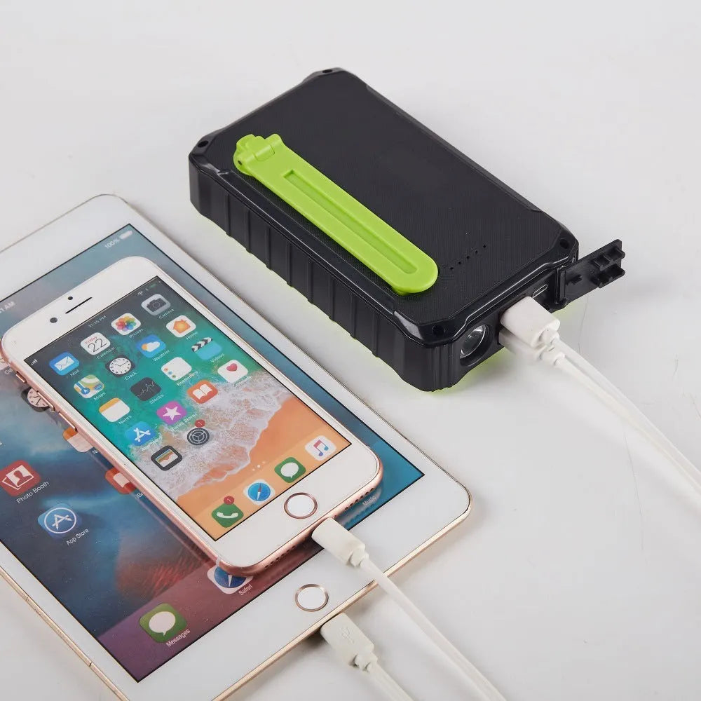 Green solar hand crank power bank with 12000mAh capacity showing USB ports and emergency LED light