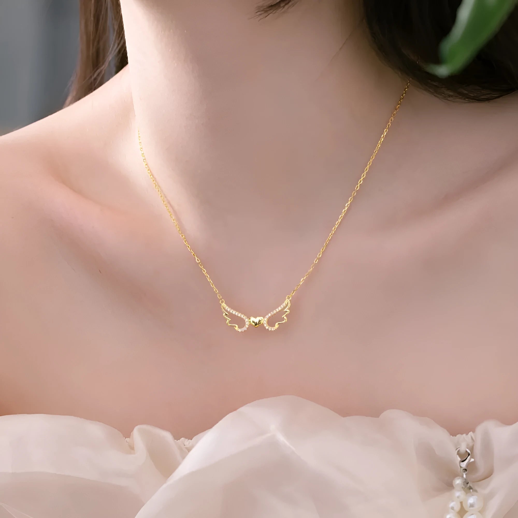 Women's 925 silver hollow-out wings love necklace on display