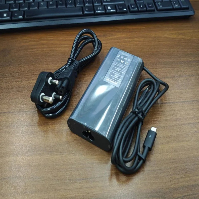 Black oval 65W Type-C laptop power adapter with multiple international plug configurations