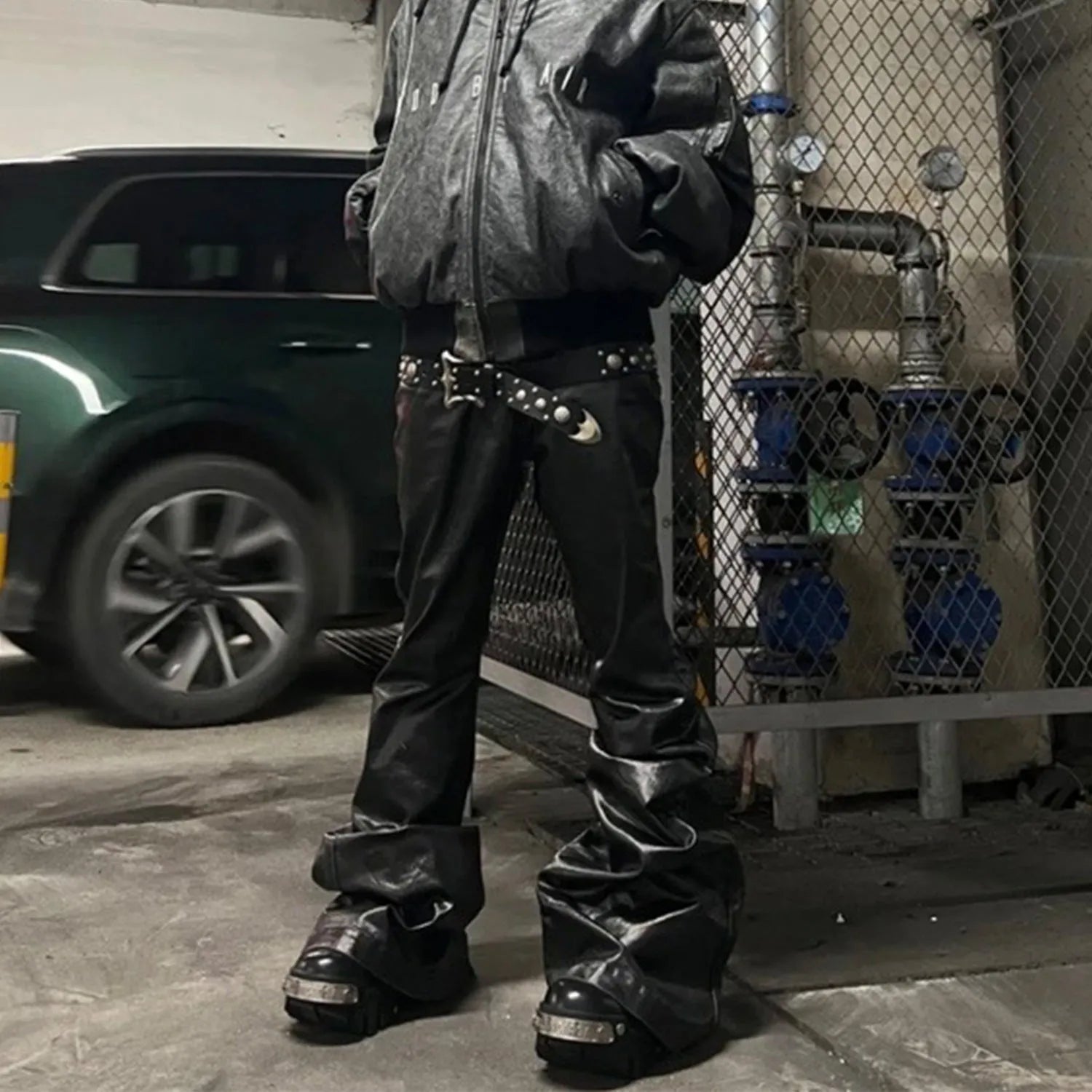 Black shiny patent leather coated skinny jeans on a denim background.