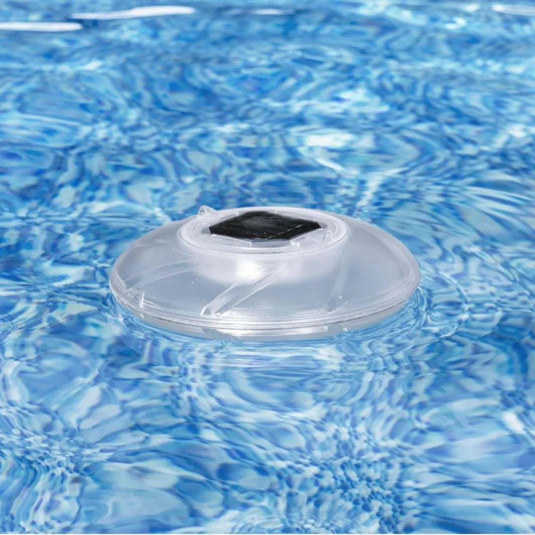 Bestway 58111 solar floating light floating on water surface in outdoor pool at dusk