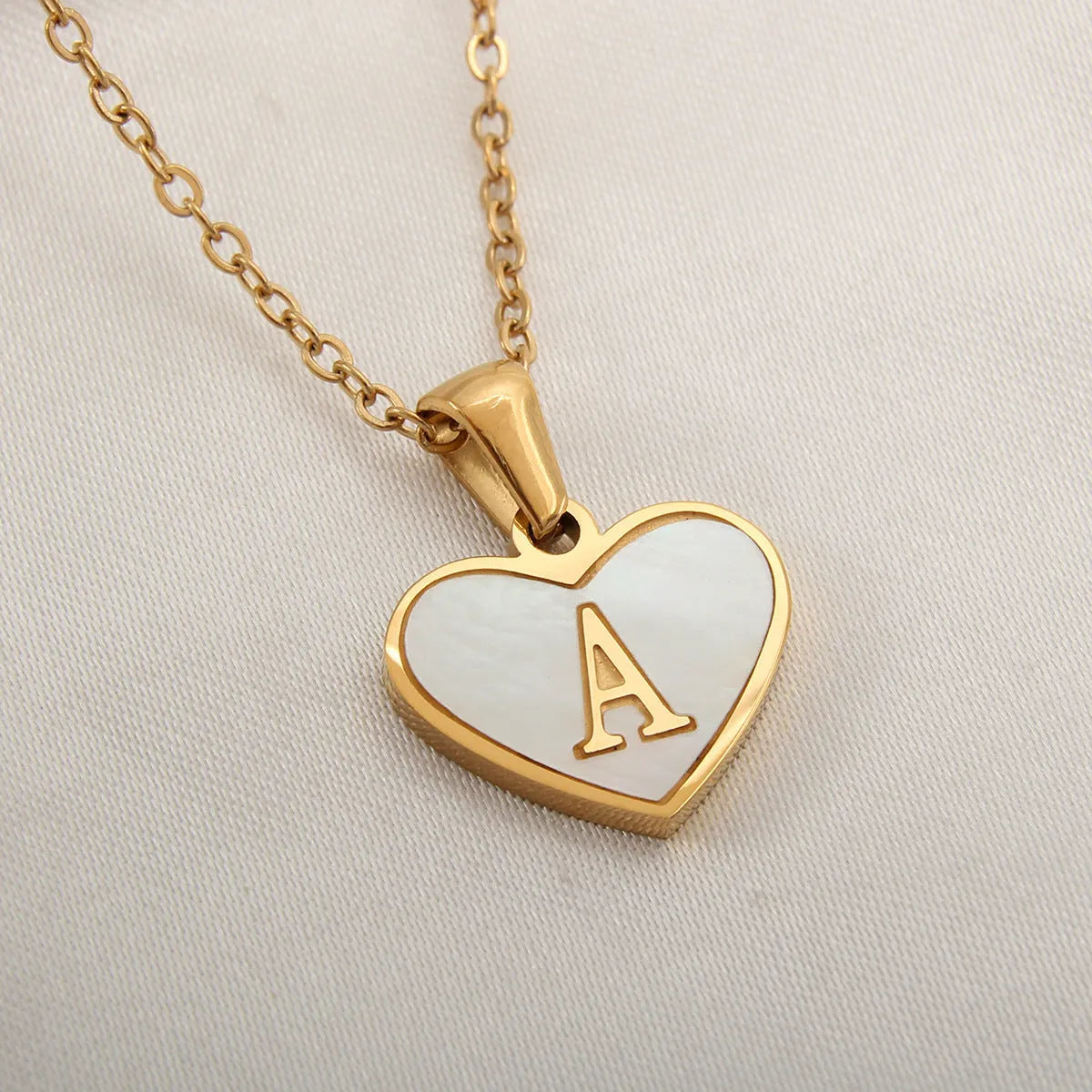 Gold plated chain necklace with a white shell heart-shaped pendant personalised with a single letter initial.