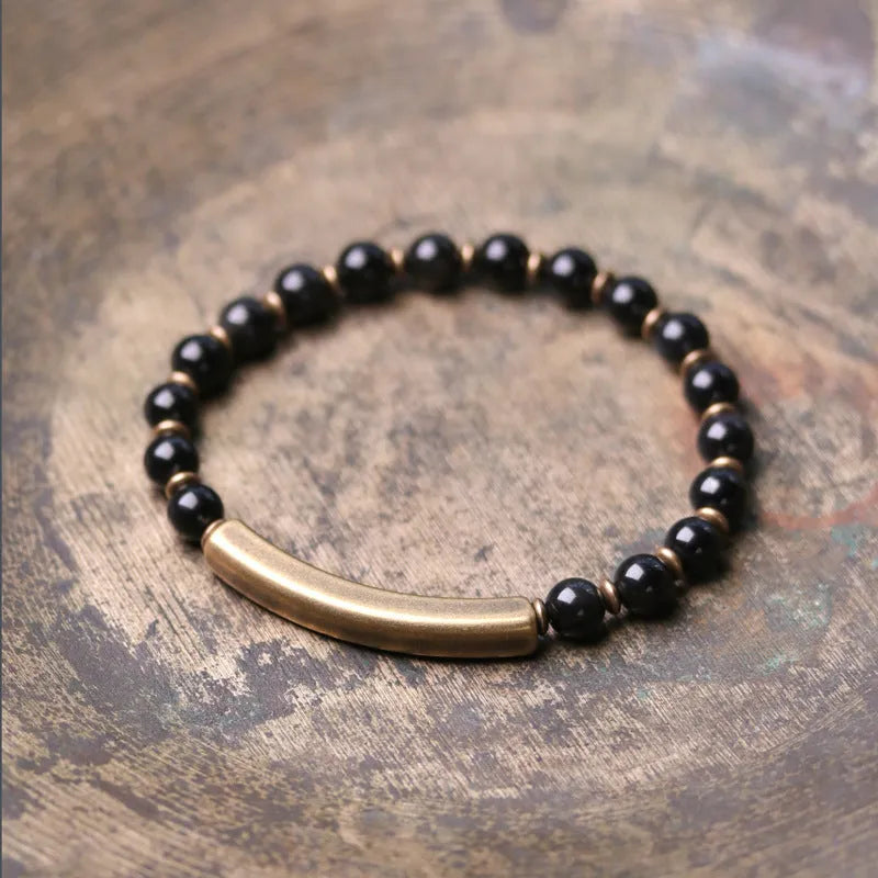 Layered ethnic bracelet with natural stones and brass components on a wrist