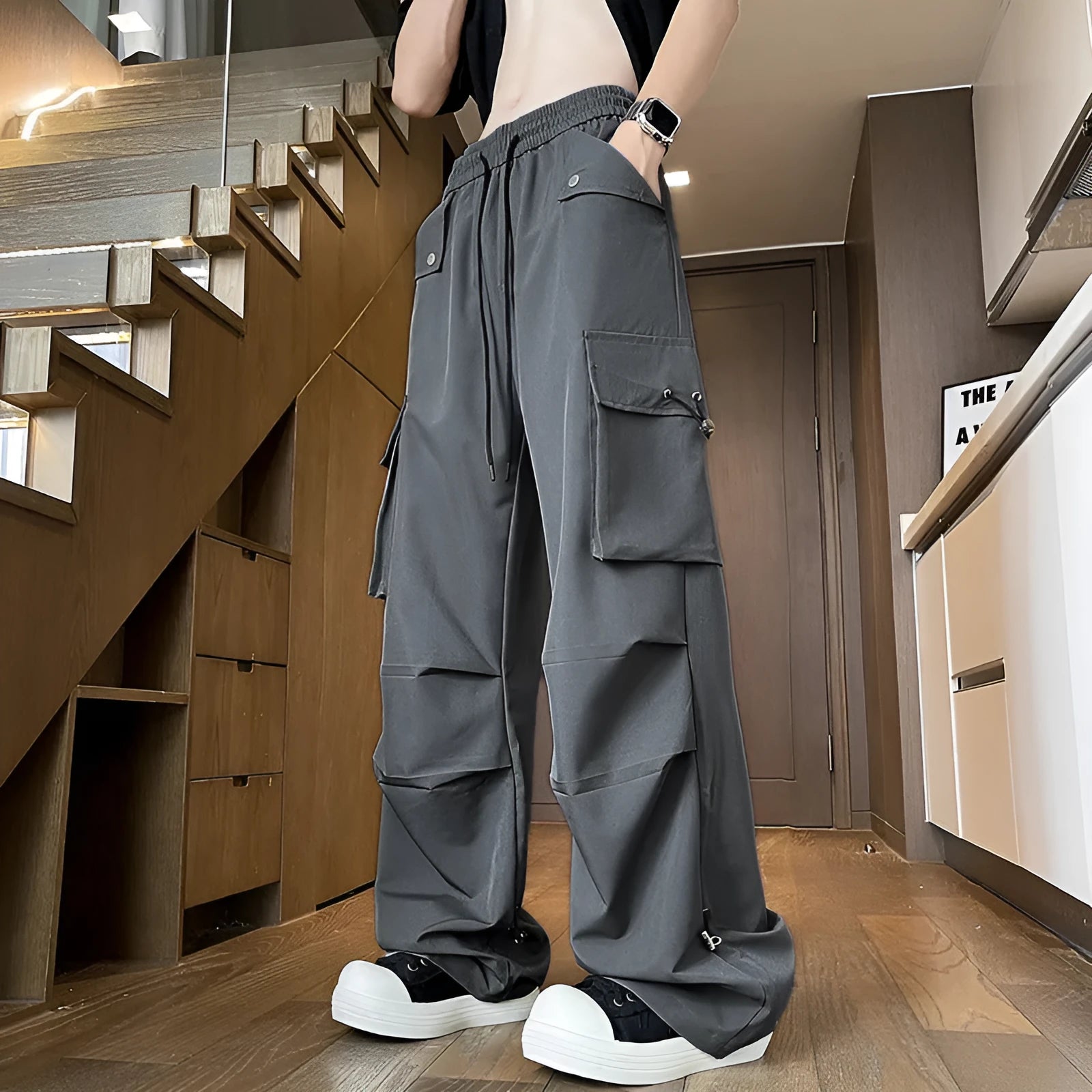 Plus size black waterproof straight-leg trousers with a drawstring waist on a hanger.
