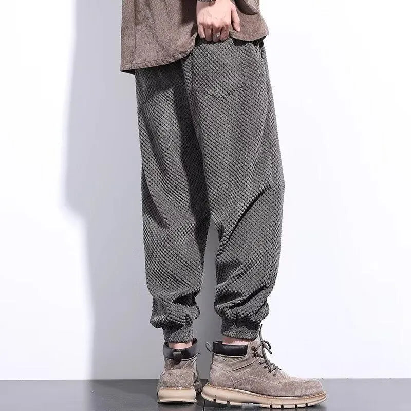 Men's grey straight leg sweatpants with ankle strap detail on a plain background.