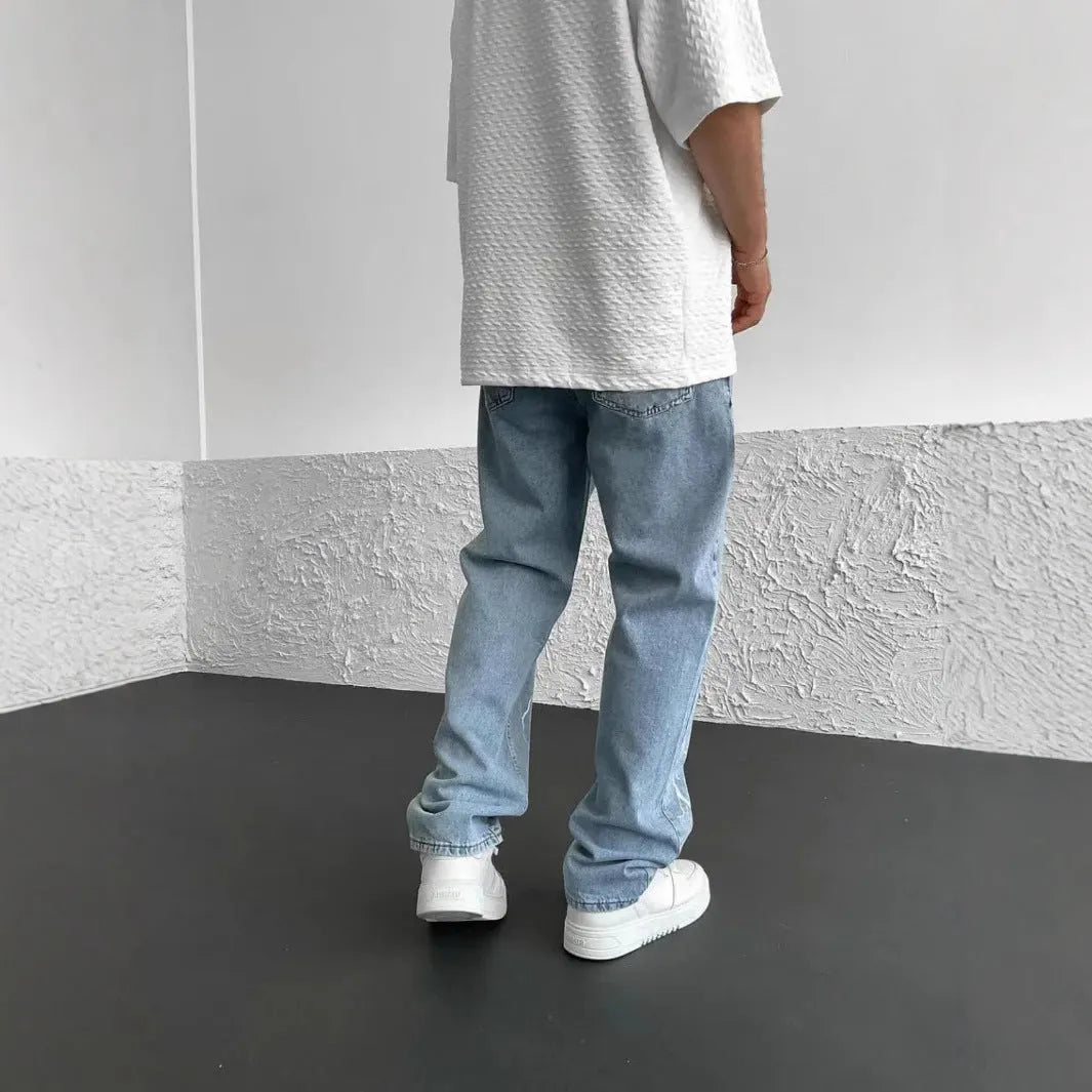 Men's blue straight-leg denim jeans with mid waist and zipper fly on solid background