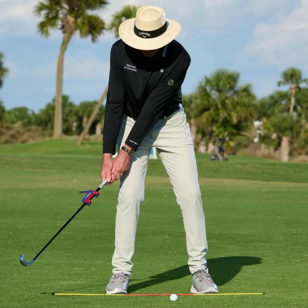 Plastic golf swing plane trainer simulator on a plain background.