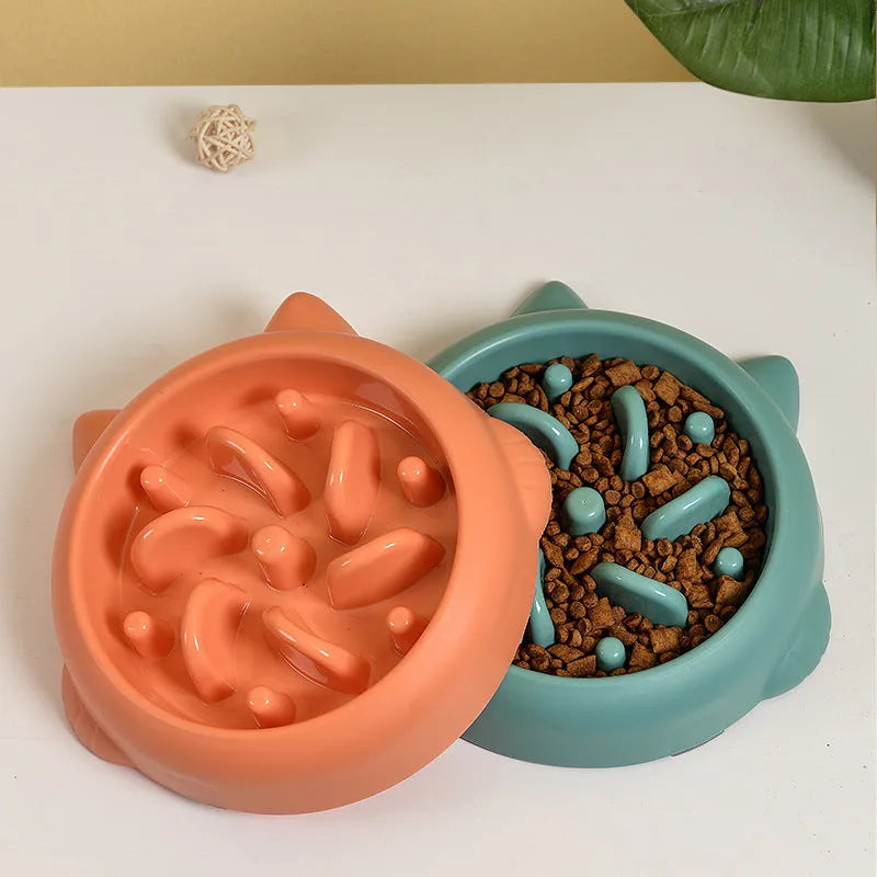 Bone-shaped slow feeder dog bowl with maze pattern in green, pink, or orange colours