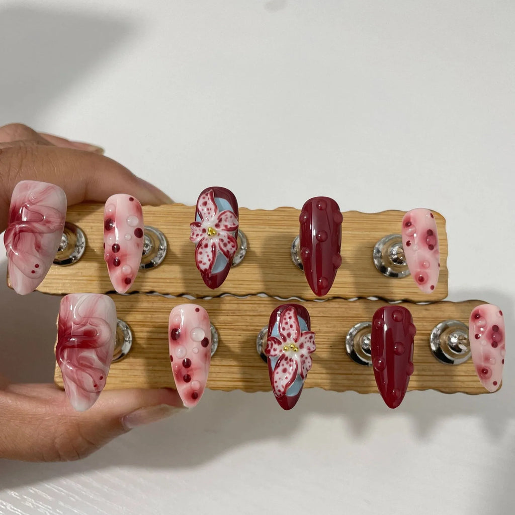 Hand-painted 3D carved press-on nails in mid-length almond shape with floral and pattern designs.