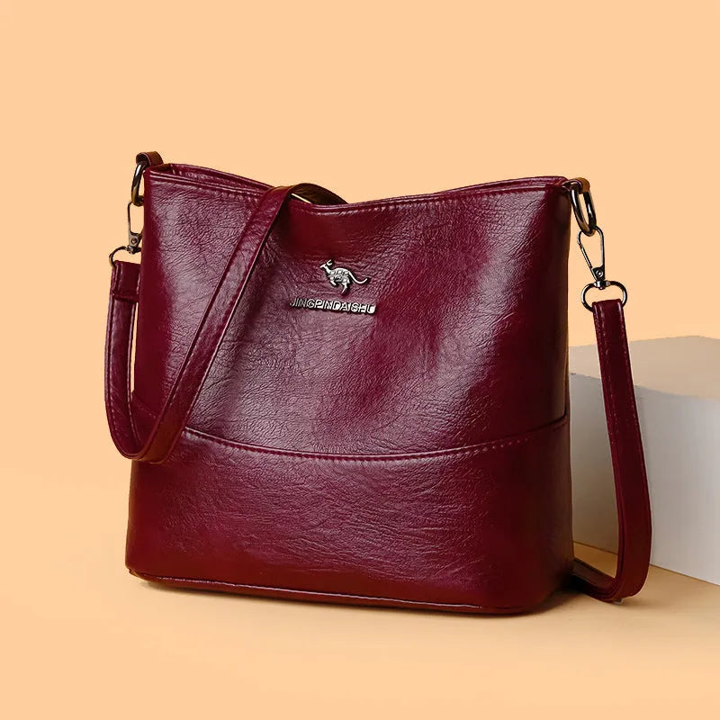 Women's soft leather bucket shoulder bag in black with visible sewing lines and phone compartment
