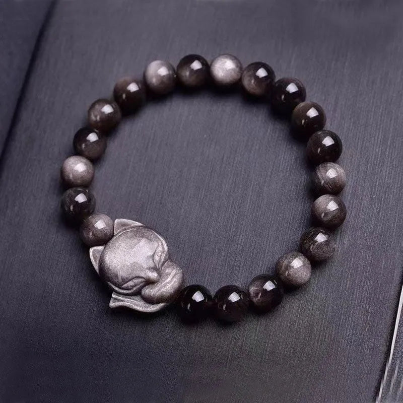 Women's obsidian bracelet with a single 8mm polished bead and a silver fox charm on an adjustable leather cord.