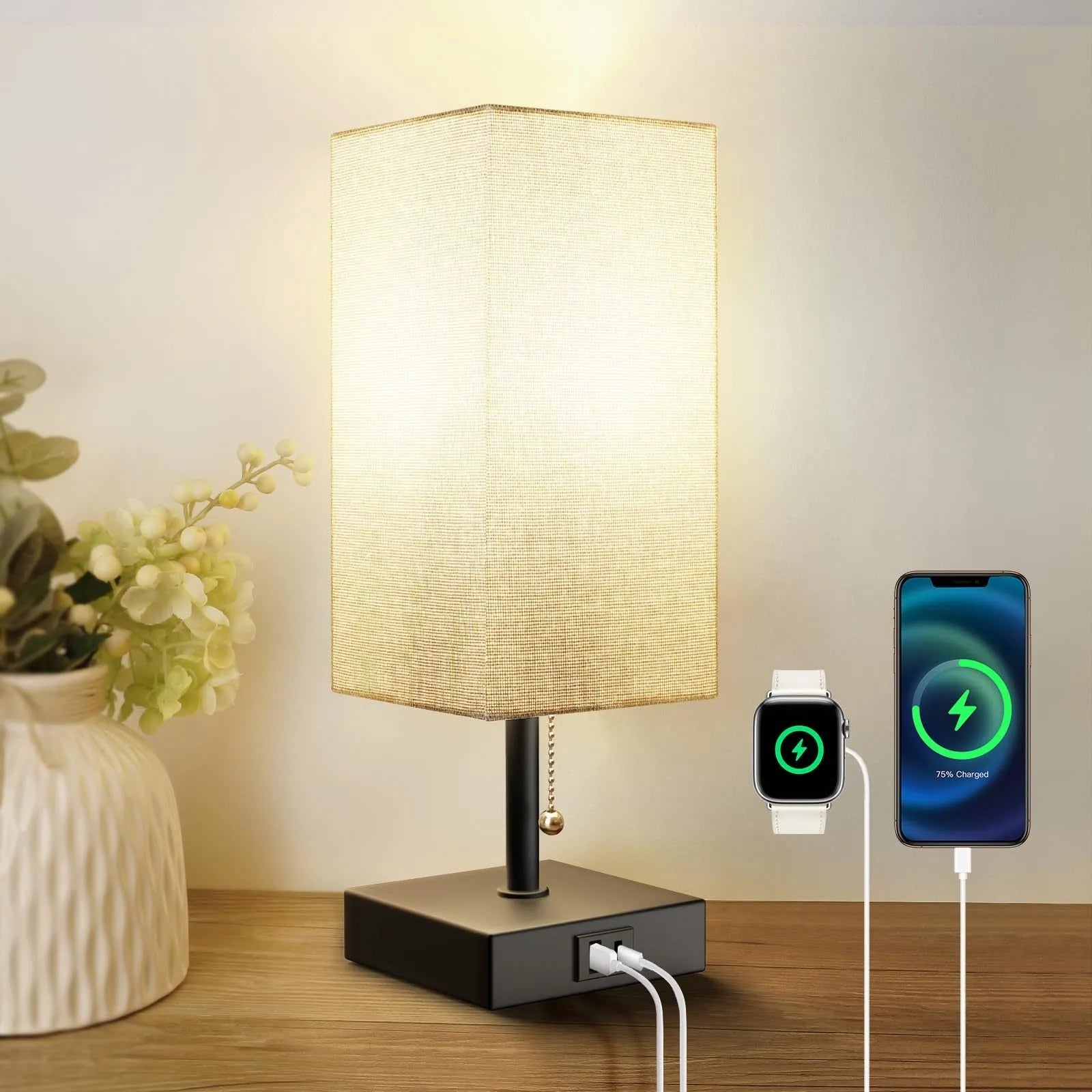 Small bedside table lamp with beige fabric shade and black base on a nightstand