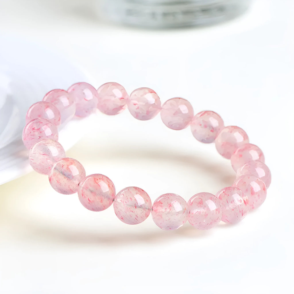 Natural white water strawberry quartz bracelet with 10-10.8mm geometric beads on a wrist.