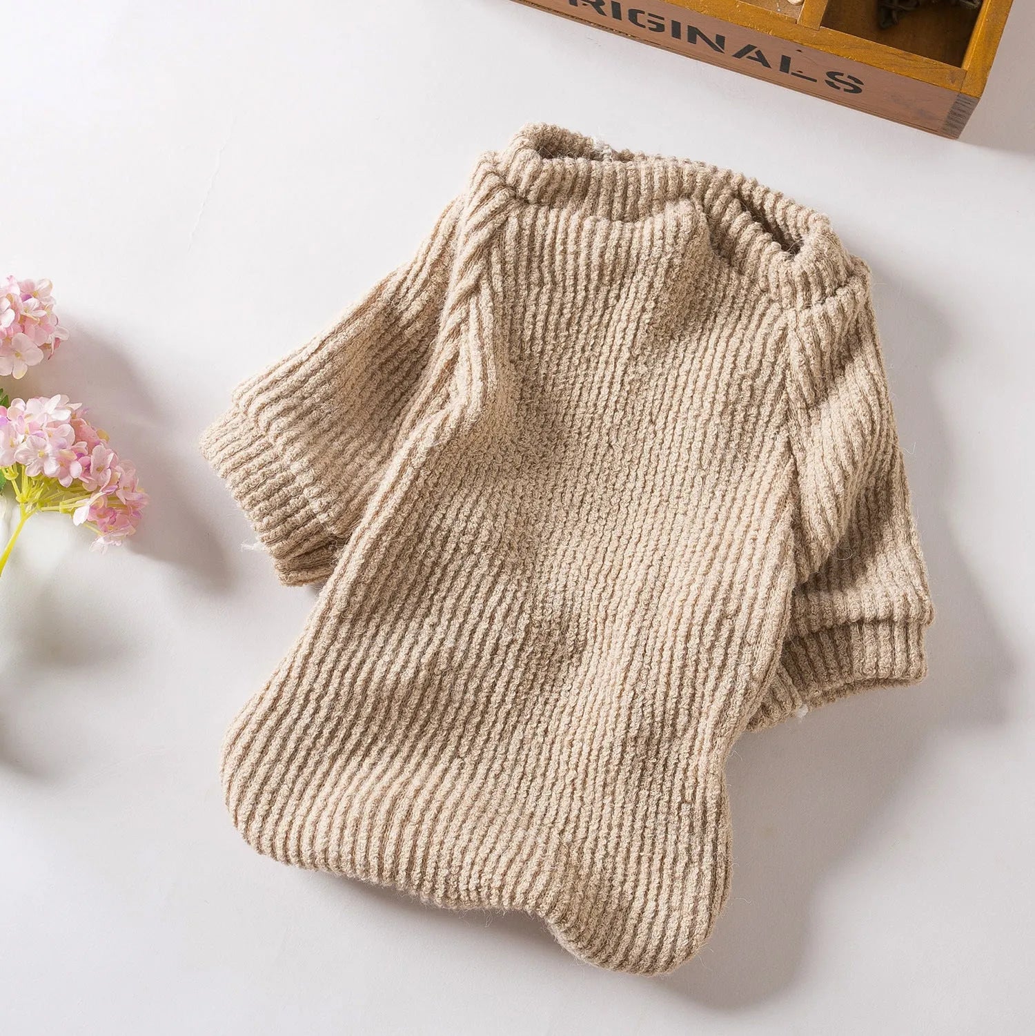 A brown cloth pullover sweater for a small dog on a white background.