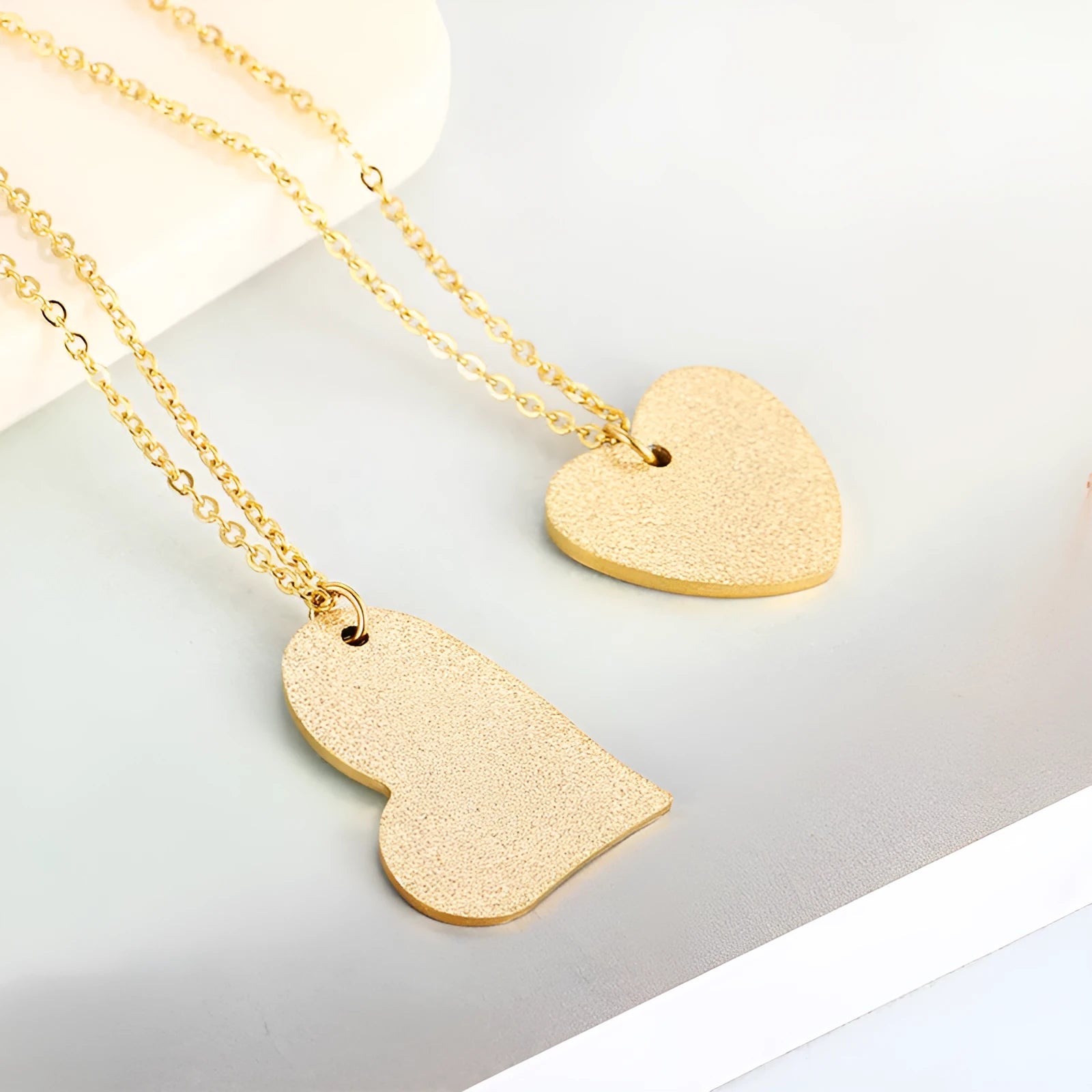 Close-up of a women's geometric heart-shaped titanium steel pendant necklace on a chain.